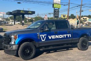 image of a blue pick up truck with the venditti llc logo on it parked on a lot
